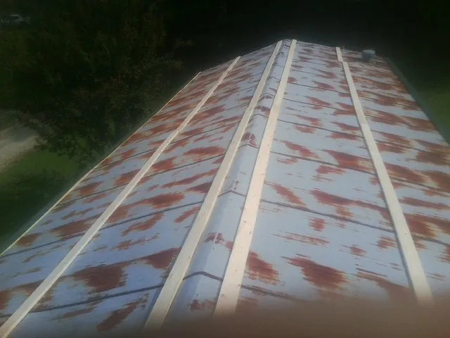 Rusted metal roof panels with new wood purlins before replacement — Storm Damage Roof Repair in Oak Hall by Roofing Brothers