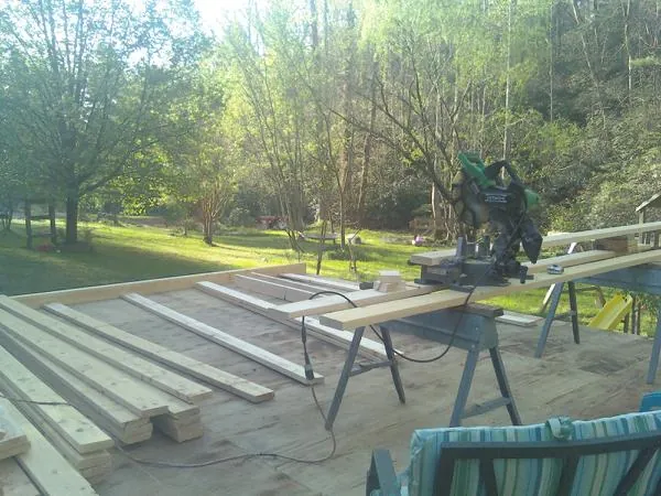 Miter saw and framing lumber on a deck under construction in Oak Hall
